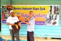 Khoirul Anwar (kiri) menyerahkan 2 buah sapu kepada pengurus mesjid Desa Aek Banir. (28/1/2023).