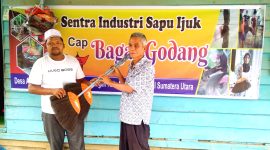 Khoirul Anwar (kiri) menyerahkan 2 buah sapu kepada pengurus mesjid Desa Aek Banir. (28/1/2023).