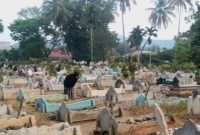 Peziarah sedang membersihkan makam keluarga yang meninggal dunia di TPU Kelurahan Sipolu-polu, Sabtu (18/3/2023).