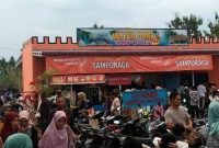 Pengunjung rela antri masuk mengambil tiket masuk ke fasilitas water park objek wisata Sampuraga, Minggu (30/4/2023).