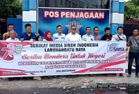 Ketua SMSI Labuhanbatu Raya, Teguh Sitorus Saat Membagikan Bendera