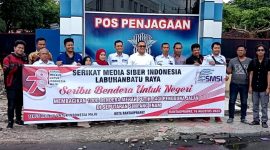 Ketua SMSI Labuhanbatu Raya, Teguh Sitorus Saat Membagikan Bendera