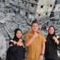 Kabag Kesra Pemkab Madina Bahruddin Juliadi foto bersama usai menerima donasi dari Ketua Karang Taruna dari Pantai Barat untuk rakyat Palestina dengan berlatar belakang sebuah pemandangan menunjukkan rumah-rumah dan bangunan yang hancur akibat serangan Israel di Kota Gaza, 10 Oktober 2023 yang diambil dari google/Reuters/Mohammed Salem.