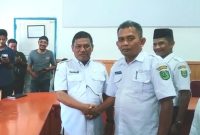 Camat Kotanopan Ahmad Pamilu, S.Sos (kiri) bersalaman dengan pejabat baru Camat Muara Sipongi Asrul Sani, S.Pd (kanan) saat Sertijab yang dipimpin oleh Sekdakab Madina H. Alamulhaq Daulay, SH, Rabu (15/11/2023).
