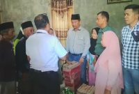 Kepala Desa Parbangunan Miswar Nasution menyerahkan bantuan sembako kepada korban kebakaran, Rabu (8/5/2024). [Foto: Joki Nasution].
