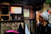 Uli, Warga Jalan Abri Panyabungan sedang menyimak Debat Publik di Warung Kopi, Lintas Barat. [Foto: Joki Nasution].